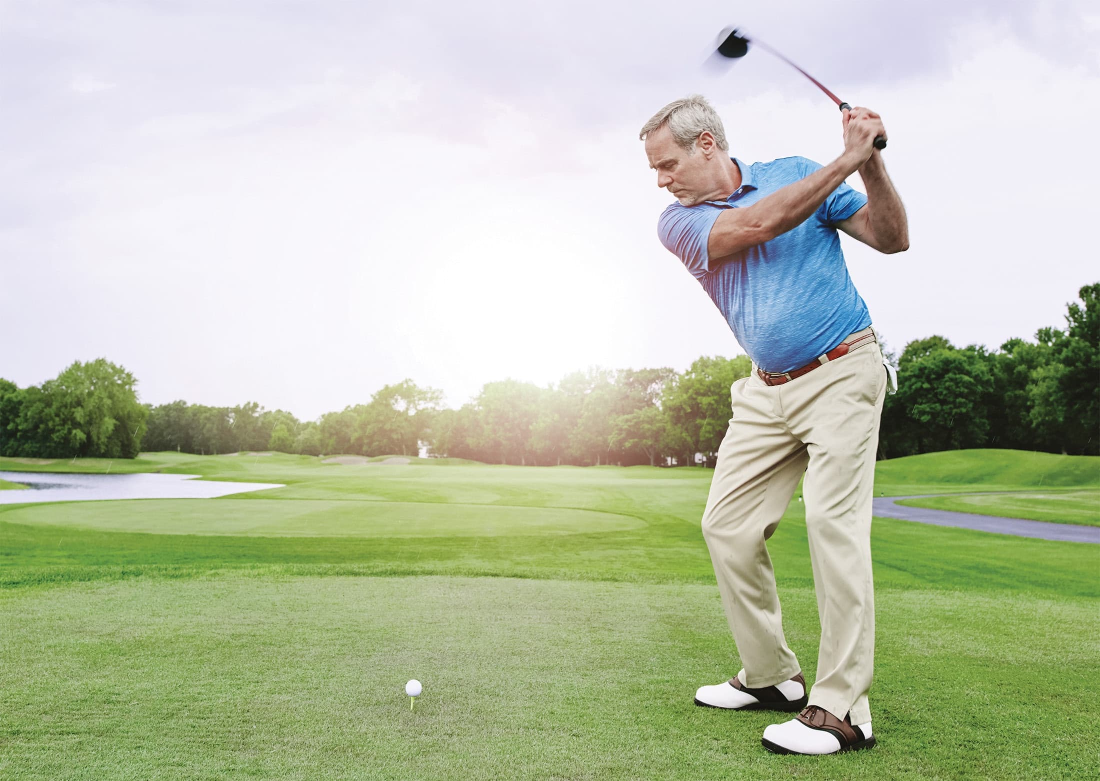 A golfer walking the fairway in the early morning